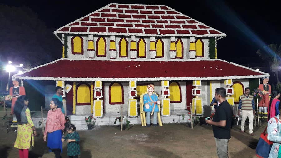 ಮಡಿಕೇರಿಯ ರಾಜಾಸೀಟ್ ಉದ್ಯಾನದಲ್ಲಿ ಶುಕ್ರವಾರ ಉದ್ಘಾಟನೆಗೊಂಡ ಫಲಪುಷ್ಪ ಪ್ರದರ್ಶನದಲ್ಲಿ ನಾಲ್ಕುನಾಡಿನ ಅರಮನೆಯ ಹೂವಿನ ಕಲಾಕೃತಿ (ಎಡಚಿತ್ರ) ಗಮನ ಸೆಳೆಯುತ್ತಿರುವ ವೈನ್ ಕಪ್ನ ಮಾದರಿ