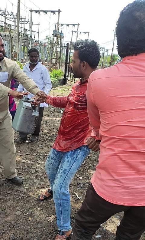 राजमाने यांच्या हातातील काडेपेटी हिसकावून घेताना महावितरणचे कर्मचारी व ग्रामस्थ.