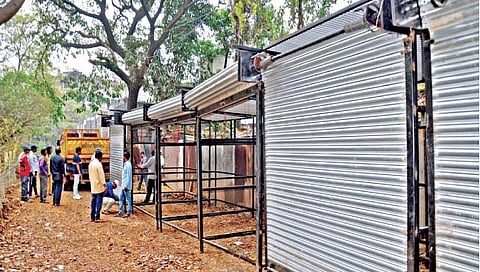 सांगली :  कॉलेज कॉर्नरसमोर पेट्रोलपंपामागील रस्त्यावर उभारलेली नवीन लोखंडी खोकी जप्त करून नेताना महापालिकेचे अधिकारी, कर्मचारी. 