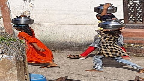 लासलगाव : शाळा सोडून डोक्यावर हंडे घेऊन फिरताना विद्यार्थी.(छाया : राकेश बोरा)