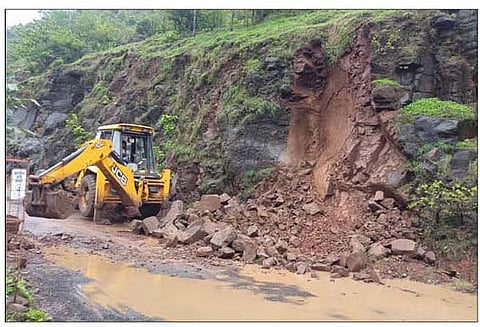 कुसगाव खिंडीत कोसळलेली दरड जेसीबीच्या साह्याने बाजूला काढताना कामगार.