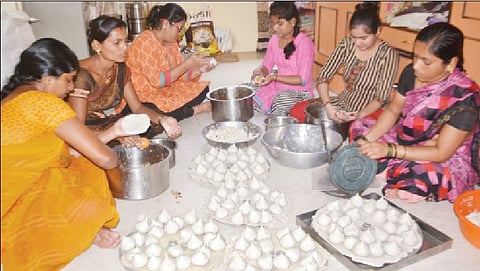 उकडीचे मोदक तयार करताना महिला.