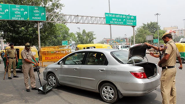 نئی دہلی کی طرف جانے والے راستے پر ایک کار کی چیکنگ کرتی ہوئی پولس