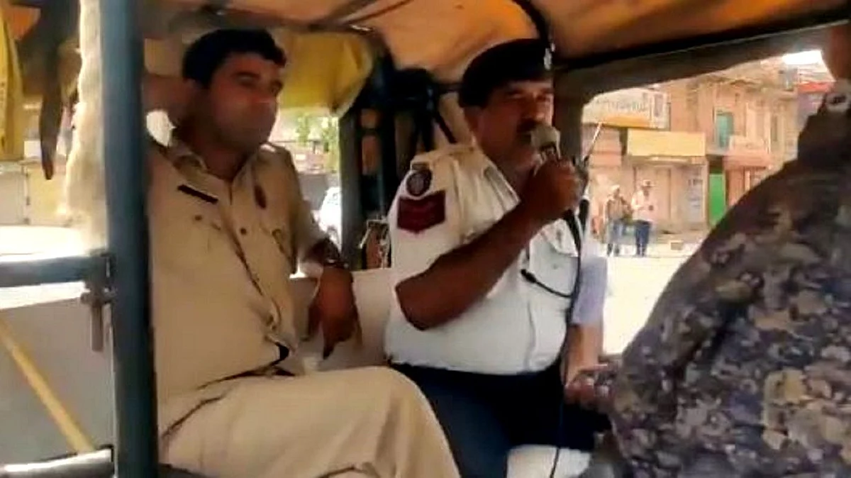 کرفیو کا اعلان کرتے ہوئے پولیس اہلکار