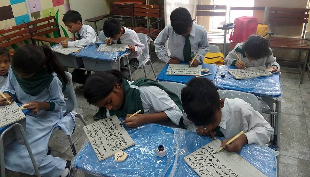 <div class="paragraphs"><p>ایک اسکول میں تختی استعمال کرتے ہوئے طلبا و طالبات / تصویر بشکریہ فیس بک</p></div>
