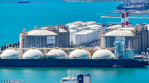 Industrial storage tanks and energy export infrastructure located along a coastal port facility.