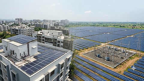 Rooftop solar installation connected with a utility-scale solar park and electrical substation.
