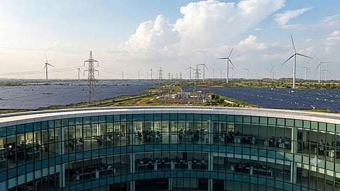 Renewable energy office overlooking solar panels, wind turbines and power lines.