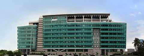 JSW corporate office building featuring a modern glass facade and the JSW logo on the main entrance.