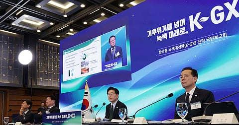 South Korean officials and industry representatives attend a K-GX green transformation strategy briefing, with a presentation screen displaying the initiative’s branding.