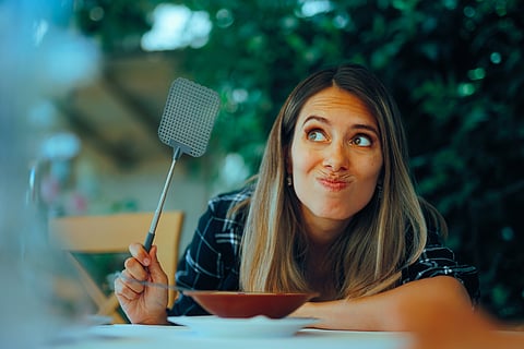 Woman watching for bugs with a flyswatter