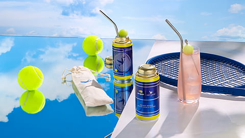 Cans of Grey Goose Honey Deuce with cocktail glass, tennis racket and balls