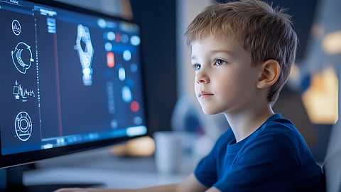 Young boy using computer with interactive 3D learning graphics on screen