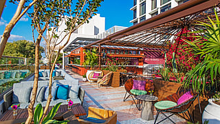 Rooftop lounge with tropical seating and vibrant bar at Serena Rooftop