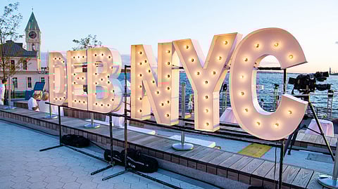 Large lit DEB NYC sign at Robert Wagner Park during Dîner en Blanc