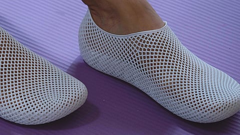 Close-up of white PollyFab Aero sneakers on purple yoga mat