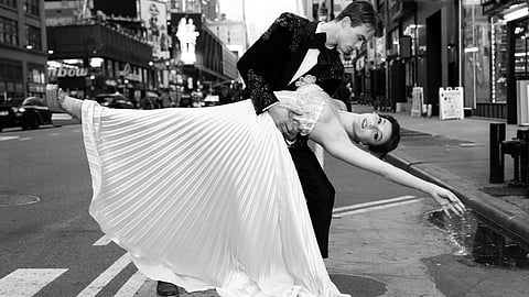 A couple poses in an elegant dip on a Manhattan street in couture attire
