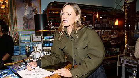 Carmen Jorda smiling while signing her new book at a SoHo launch event