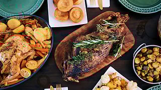 Thanksgiving feast with roast turkey, lamb, vegetables, and puddings