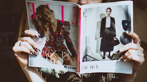 Woman reading a fashion magazine highlighting luxury trends