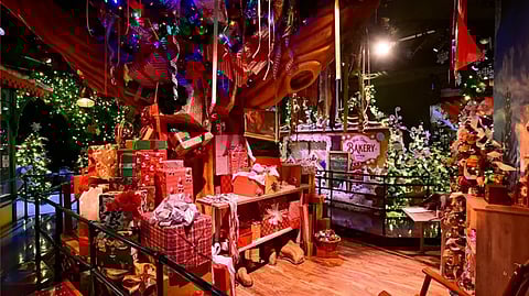 Macy’s Santaland holiday display with lights, gifts, and Christmas trees
