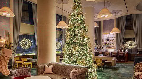 Grand Christmas tree glowing in The Wall Street Hotel’s festive holiday lobby