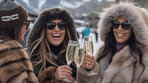 Women in fur coats enjoying champagne during après-ski in snowy Courchevel