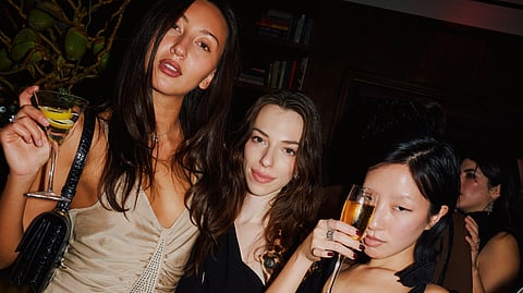 Three guests enjoying cocktails during the Moss opening celebration