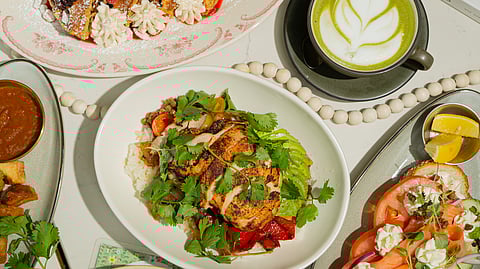 Café Bastille brunch dishes with waffles, chicken bowl, toast, and matcha latte