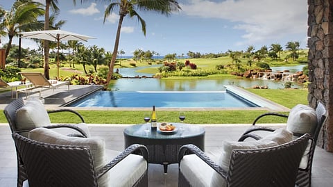 Lanai with seating overlooking pool, gardens, and ocean at Kukui‘ula