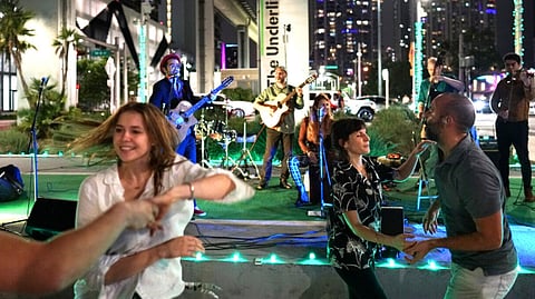 People dancing at a nighttime concert under The Underline sign