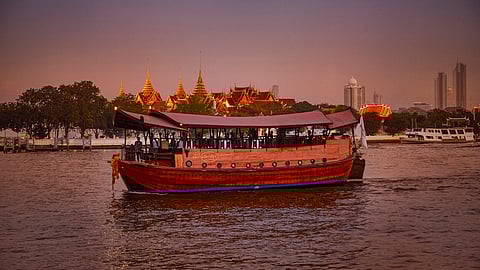 Manohra rice barge sailing the Chao Phraya River at sunset