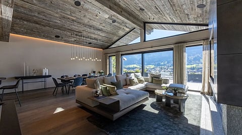 Living room with large windows, mountain views, and vaulted wood ceiling in Kitzbühel