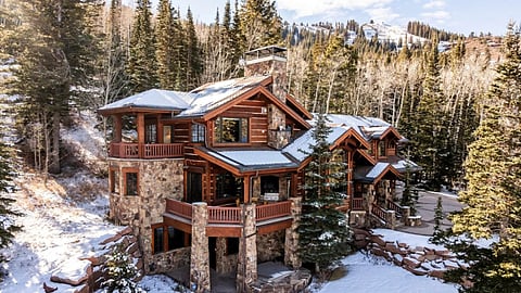 Exterior view of the Dream Catcher Lodge nestled in a forested, snowy mountainside