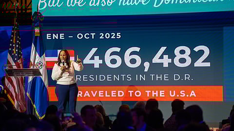 Speaker onstage presenting Dominican Republic travel statistics at New York event