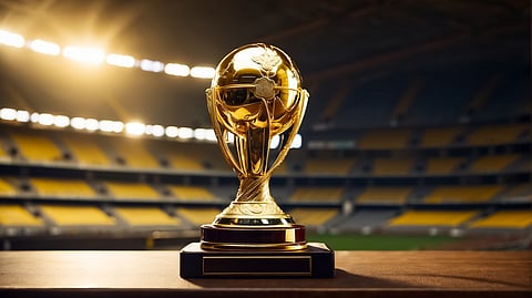 Gold World Cup–style trophy displayed inside a brightly lit stadium