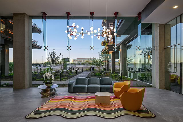 Contemporary residential lobby with floor-to-ceiling glass and landscaped courtyard views