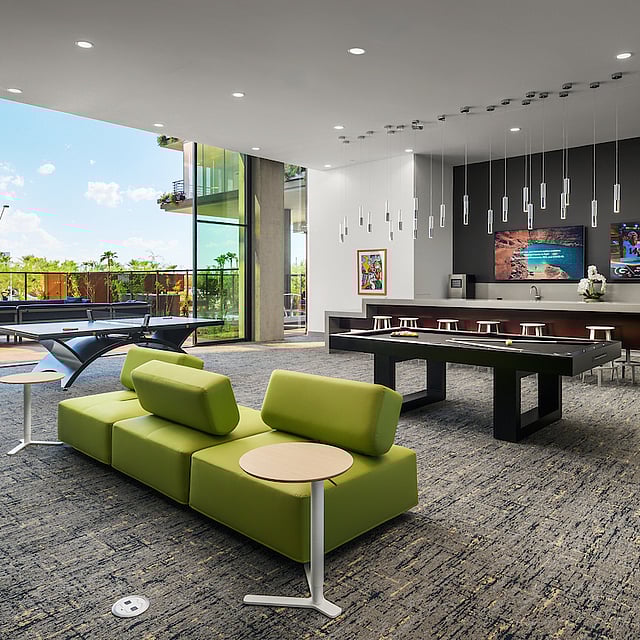 Modern resident lounge with pool table, bar seating, and floor-to-ceiling glass