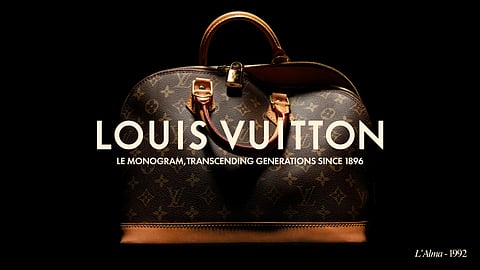 Louis Vuitton Alma bag in Monogram canvas photographed against a black background