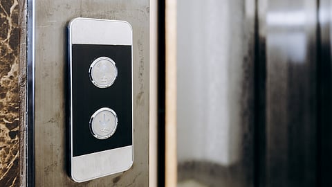 Close-up of a modern residential elevator control panel with up and down buttons