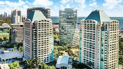 Aerial view of The Ritz-Carlton Coconut Grove towers surrounded by palm trees and Biscayne Bay