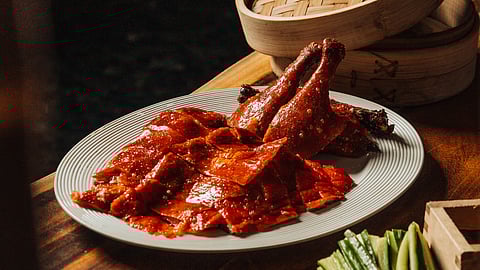 Plated Peking duck with crispy skin, cucumber, and scallions at Komodo Miam