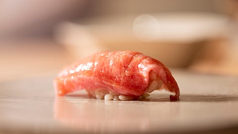 Otoro nigiri showcased on a minimalist wooden sushi counter
