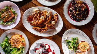 Luxury brunch dishes at Delilah Miami during SOBEWFF, chicken and waffles and eggs Benedict
