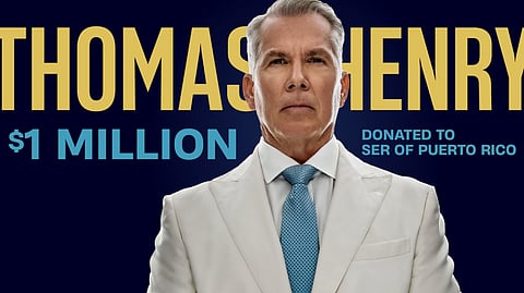Thomas J. Henry in a white suit and blue tie, announcing a $1 million donation to SER of Puerto Rico