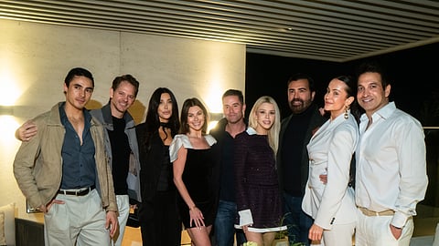 Group of guests posing together at a private rooftop event in Beverly Hills at night