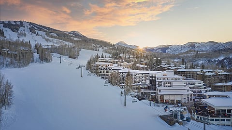 Aerial view of Viewline Resort Snowmass at sunrise with ski slopes, chairlifts, and mountain village