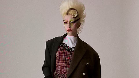 Model in oversized tailoring and tartan dress from Charles Jeffrey LOVERBOY AW26 Thistle collection