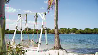 Waterfront seating and palm-lined shoreline at Joia Beach in Miami