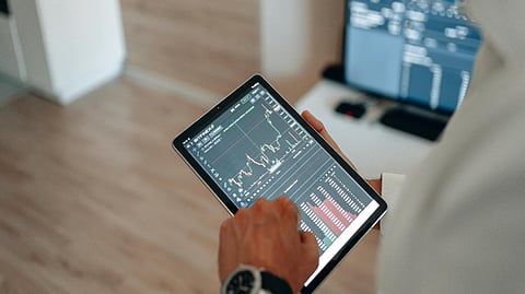 Person using a tablet to view online casino review and gaming platform charts